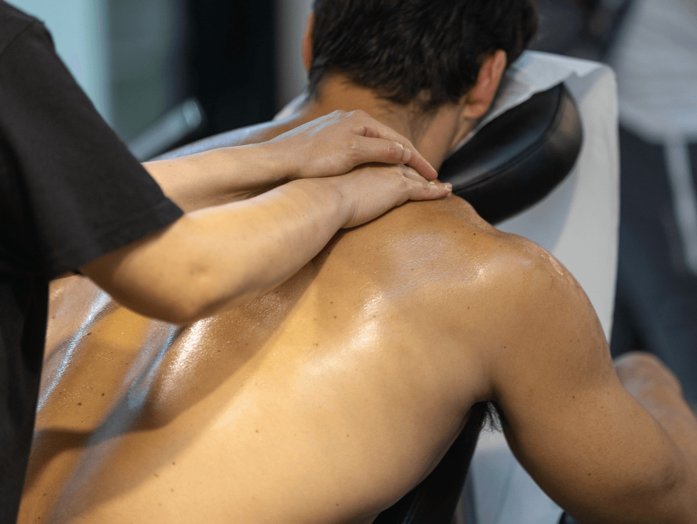 Therapist working on a client’s back during a mid-length sports massage session.