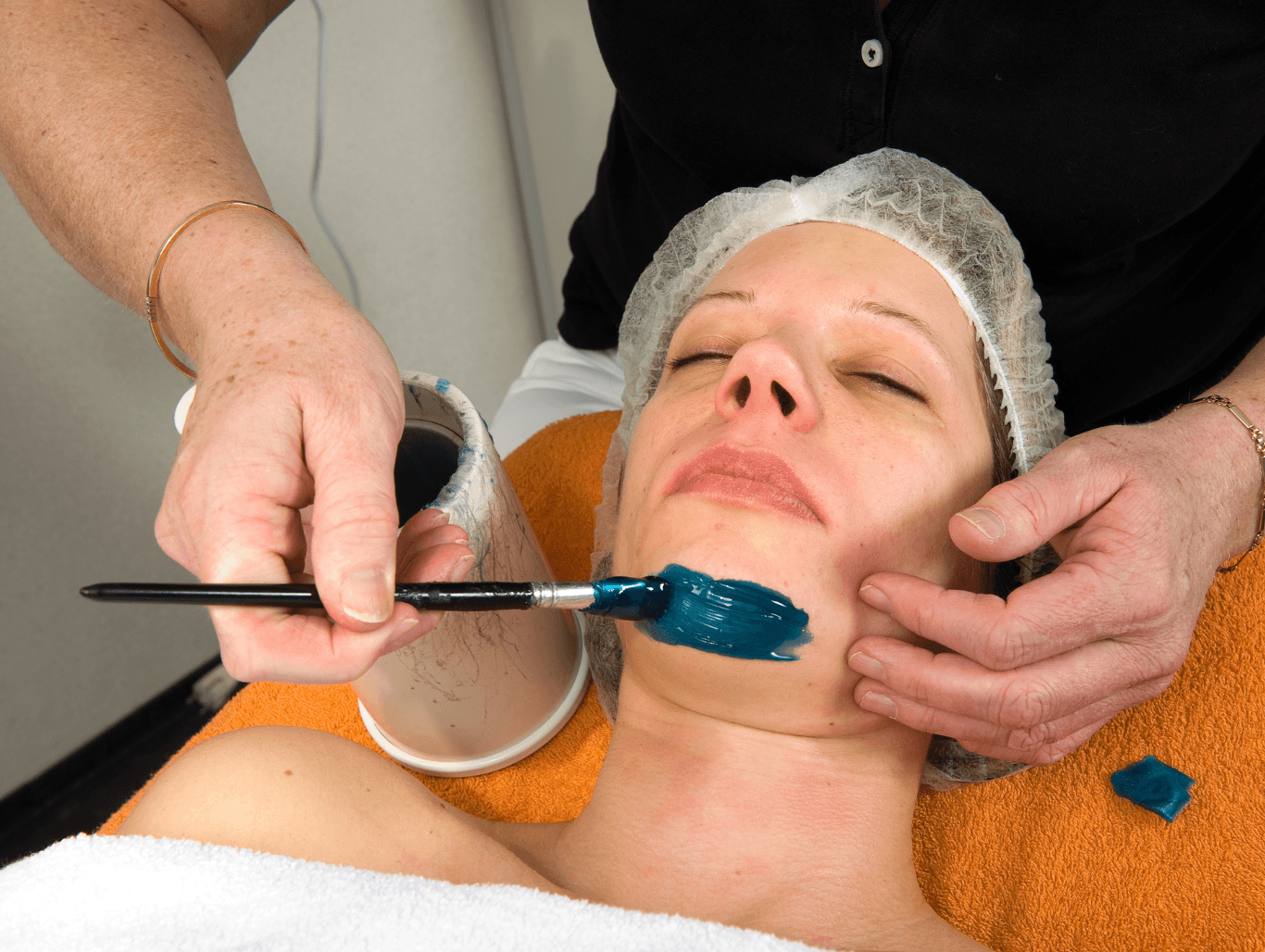 A beauty salon client receiving a professional chin waxing treatment to remove unwanted facial hair, ensuring smooth and clean skin.