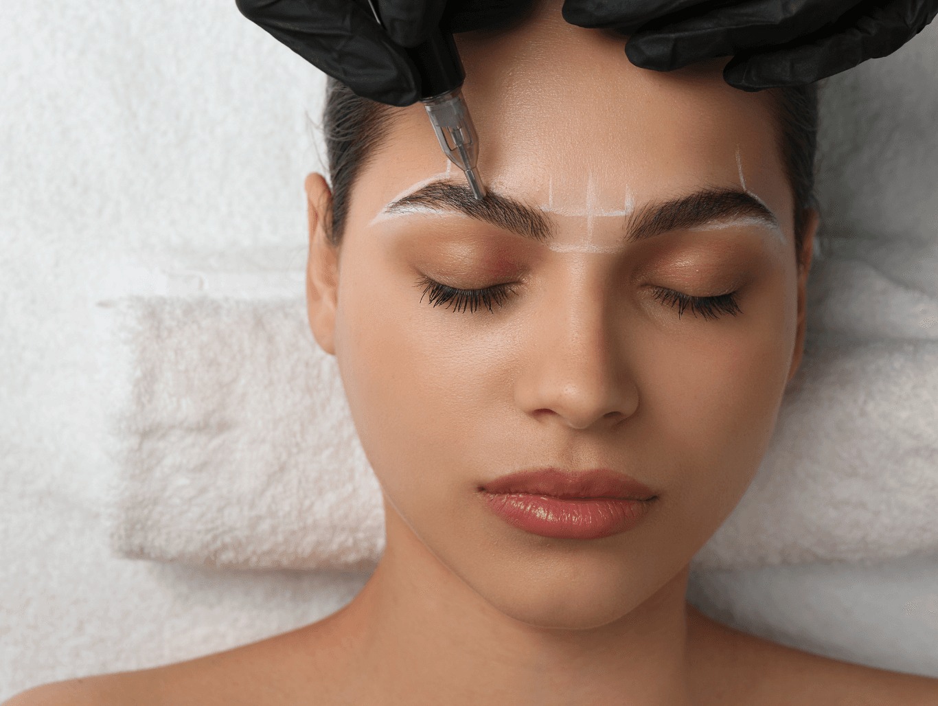 A beauty therapist using mapping and precision tools to shape and define a client’s eyebrows during a Glamour Brow treatment in Eastbourne.