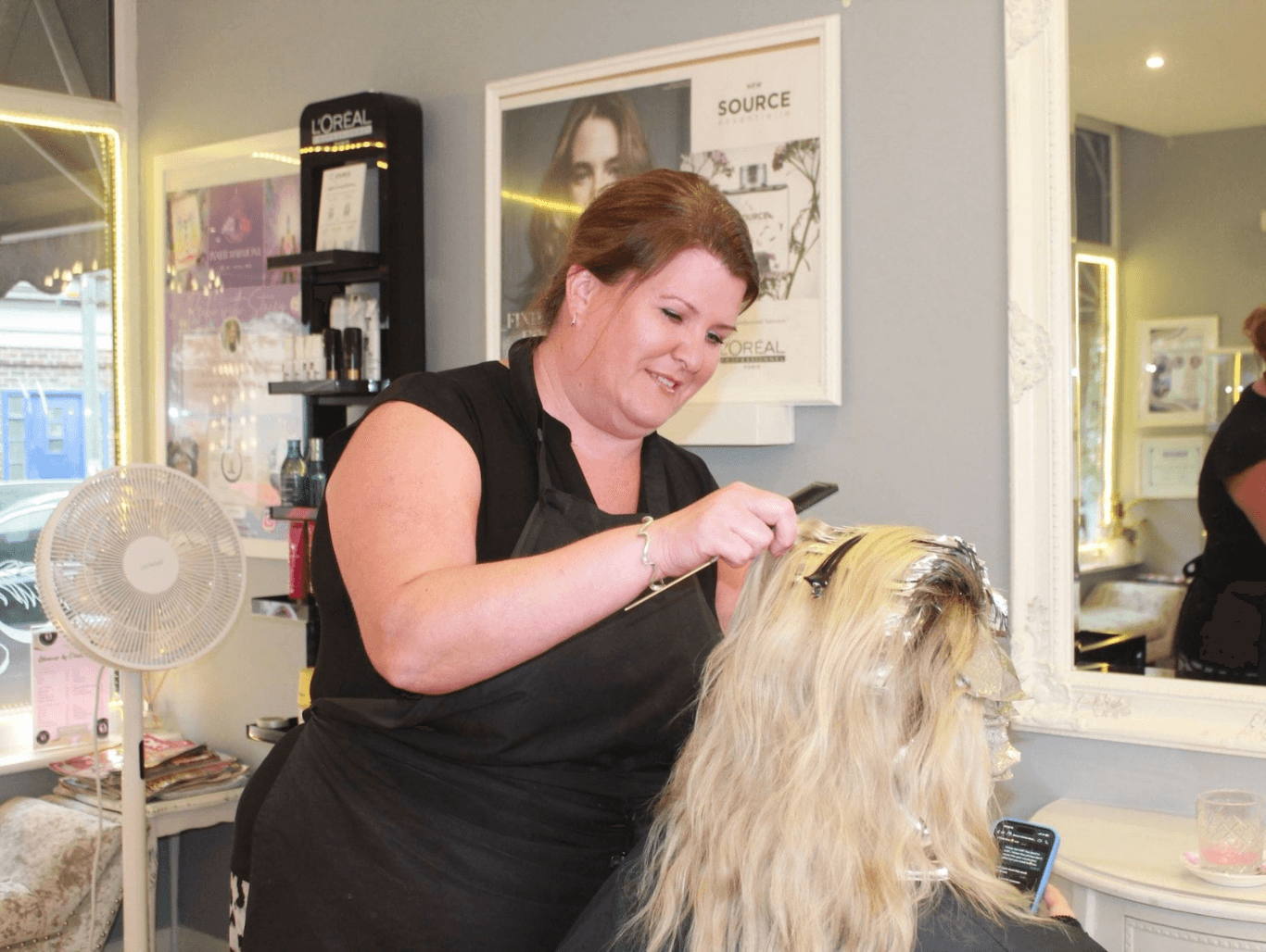 Stylist applying highlights at The Dolls House Hair & Beauty Boutique in Eastbourne – expert colour services tailored to brighten and enhance your look.