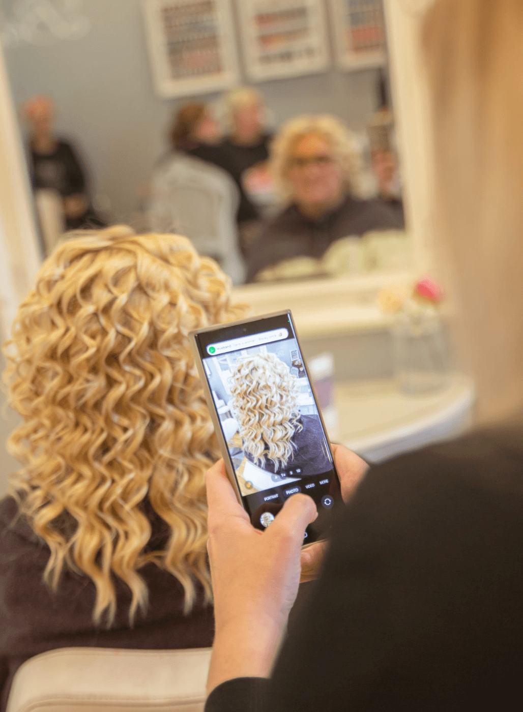 Freshly permed blonde curls at The Dolls House Hair & Beauty Boutique in Eastbourne – stylist capturing finished results of a modern perm service.